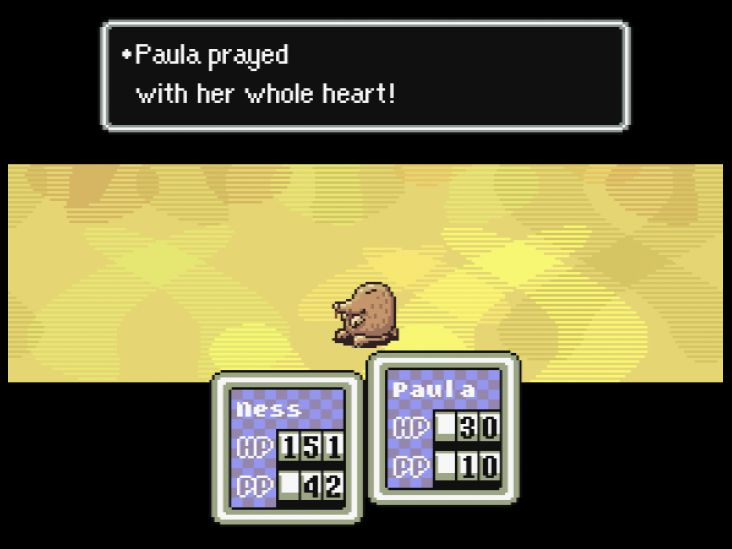 Paula prays during a battle with a Mole Playing Rough.